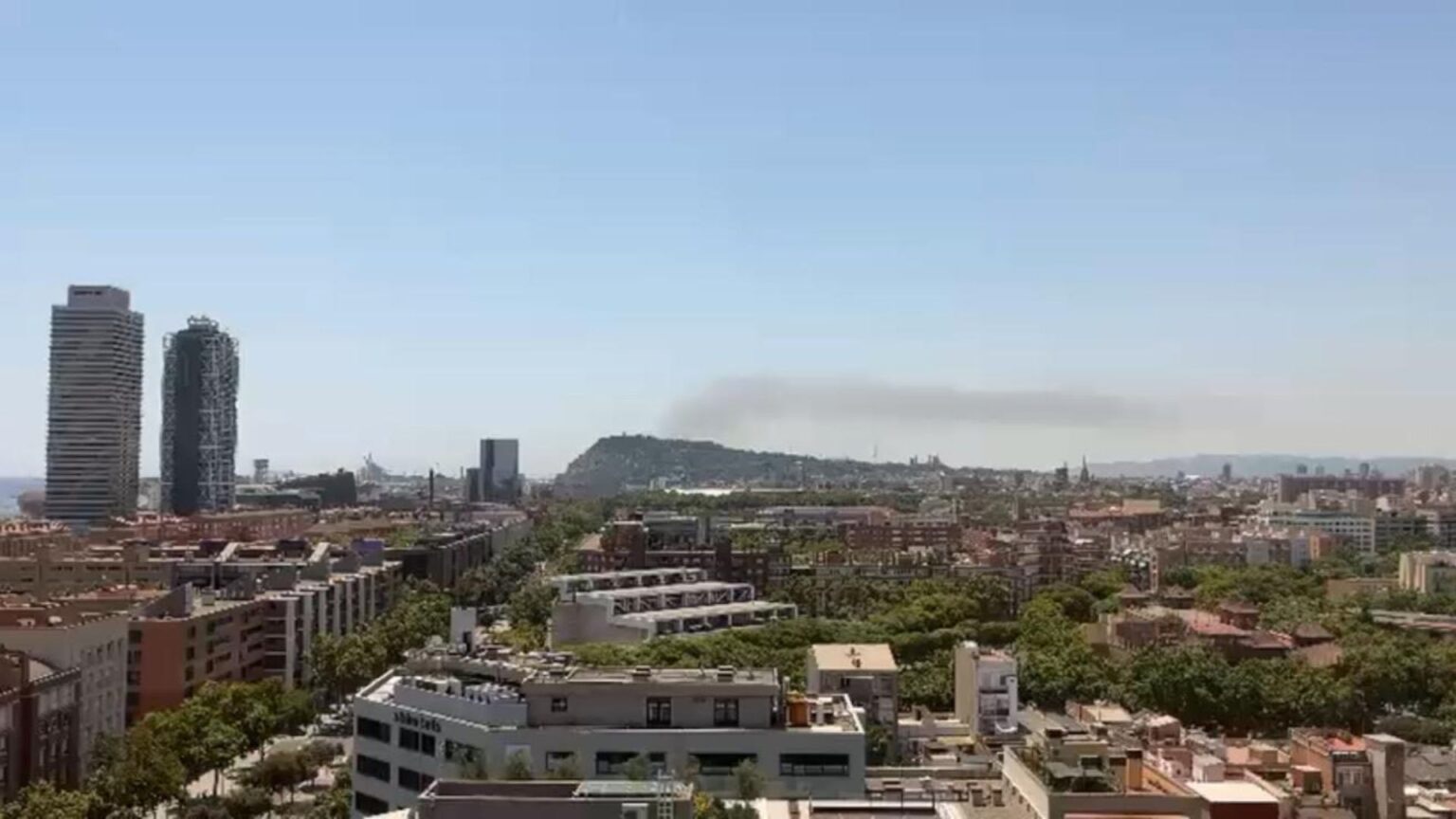 Incendio en una zona de barracas junto al polígono industrial del Prat de Llobregat, visible desde Barcelona